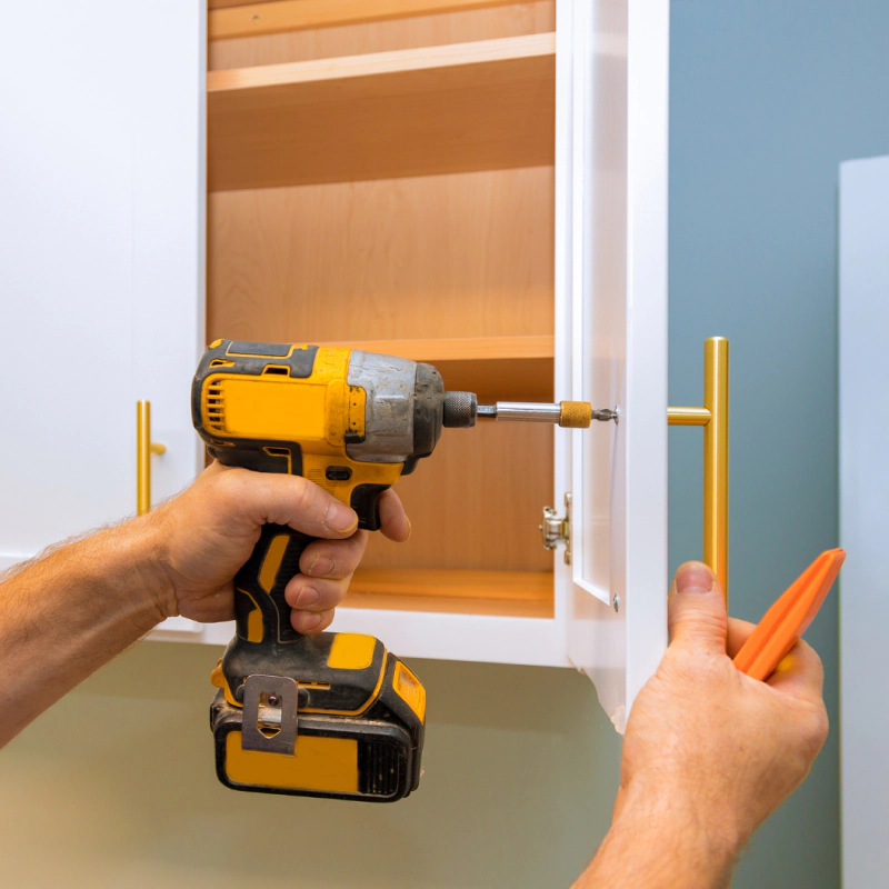 man drilling cabinet